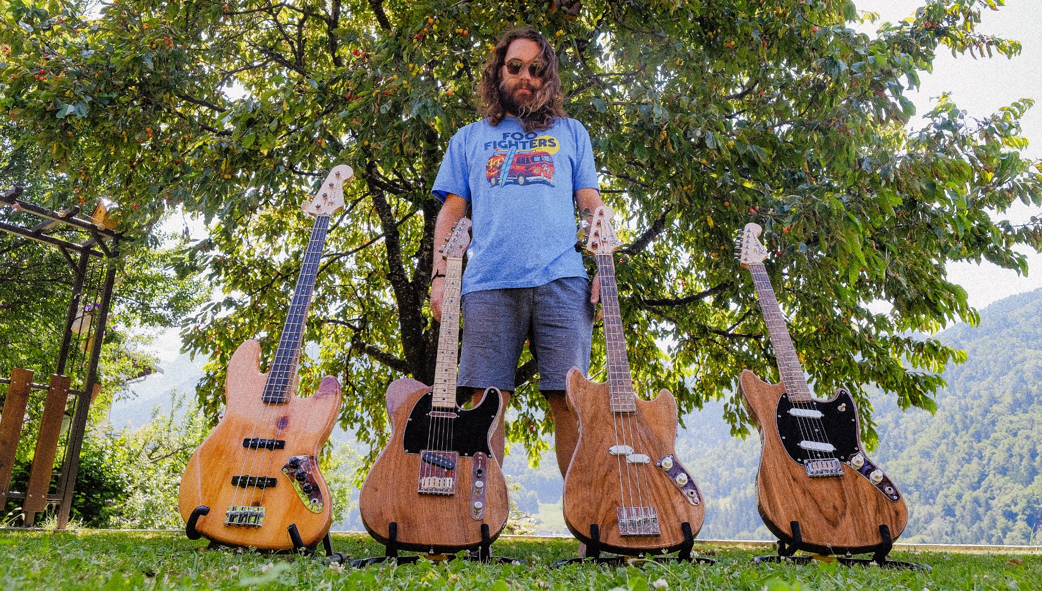 Ludo Roche avec quatre guitares et basses Instruments Roche fabriquées avec son père